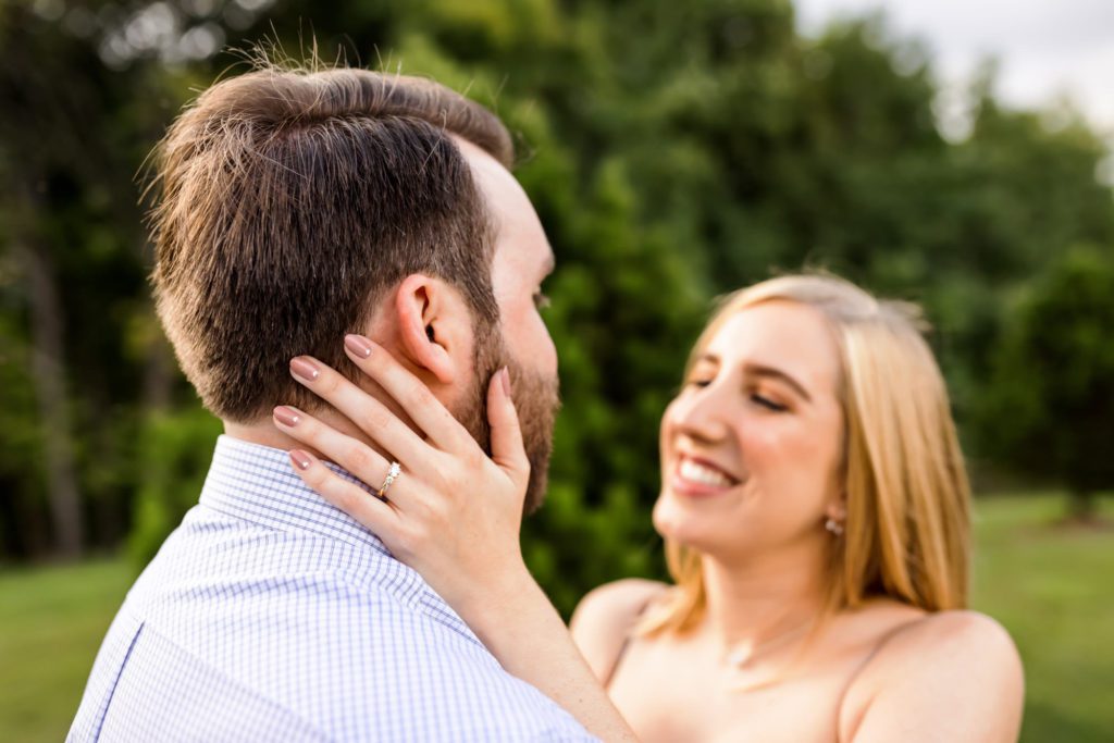 woman holding man's face during outdoor engagement session