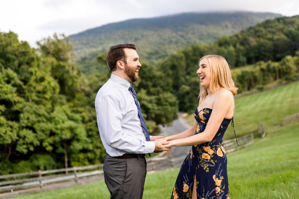 couple holding hands and swaying in field during lexington engagement pictures