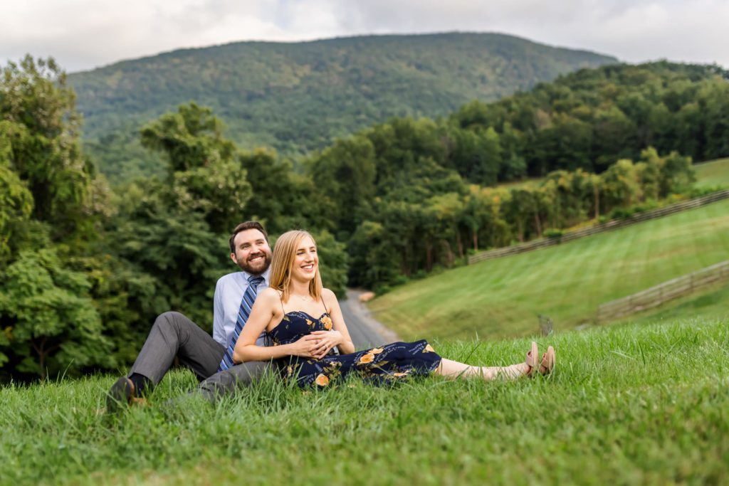 couple sitting in grass during engagement pictures in Lexington
