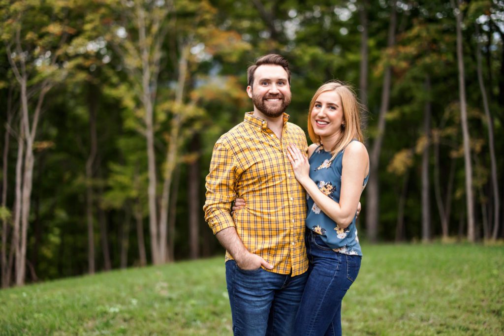 engaged couple embracing wearing blue and yellow during outdoor engagement session
