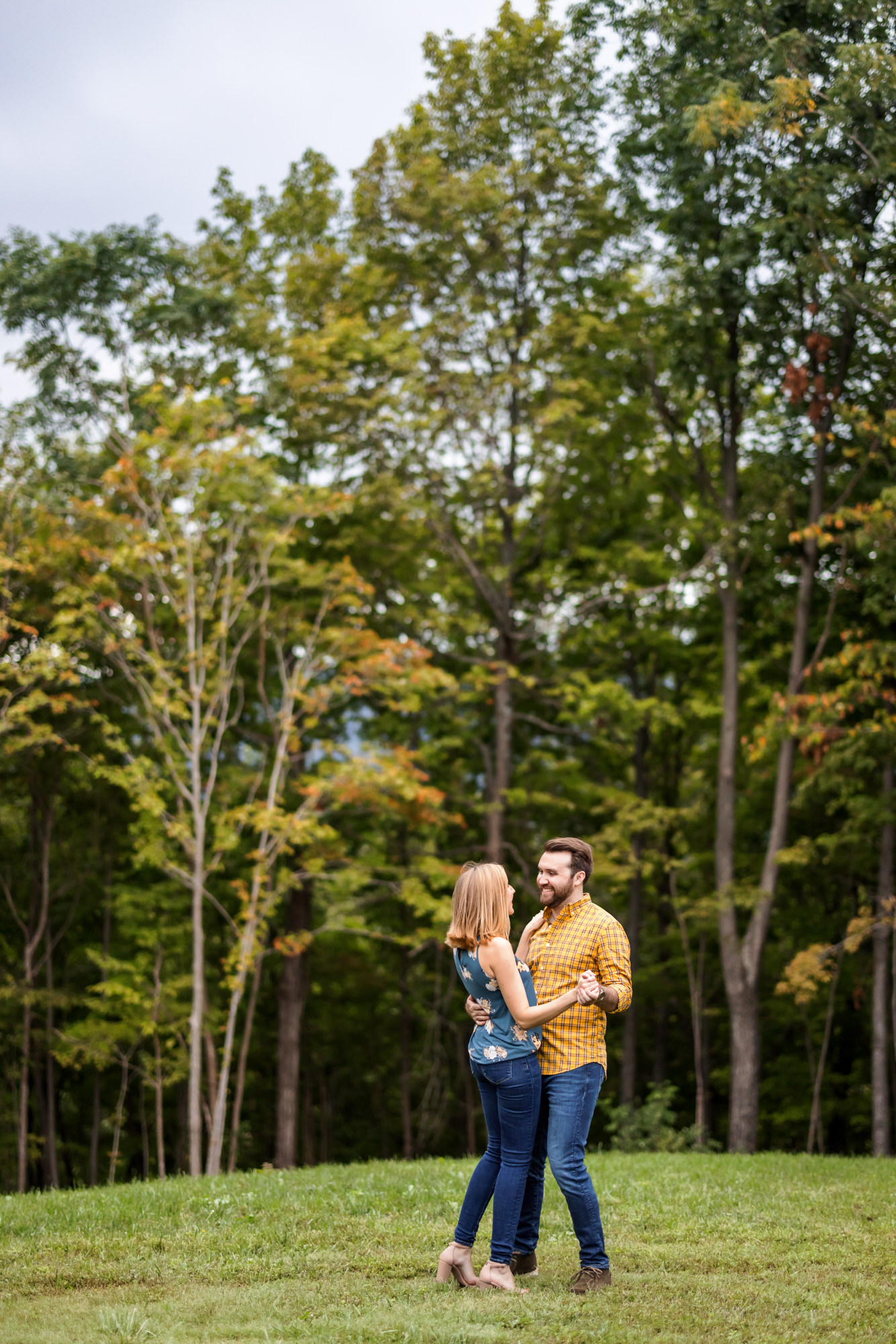 couple dancing in field by trees