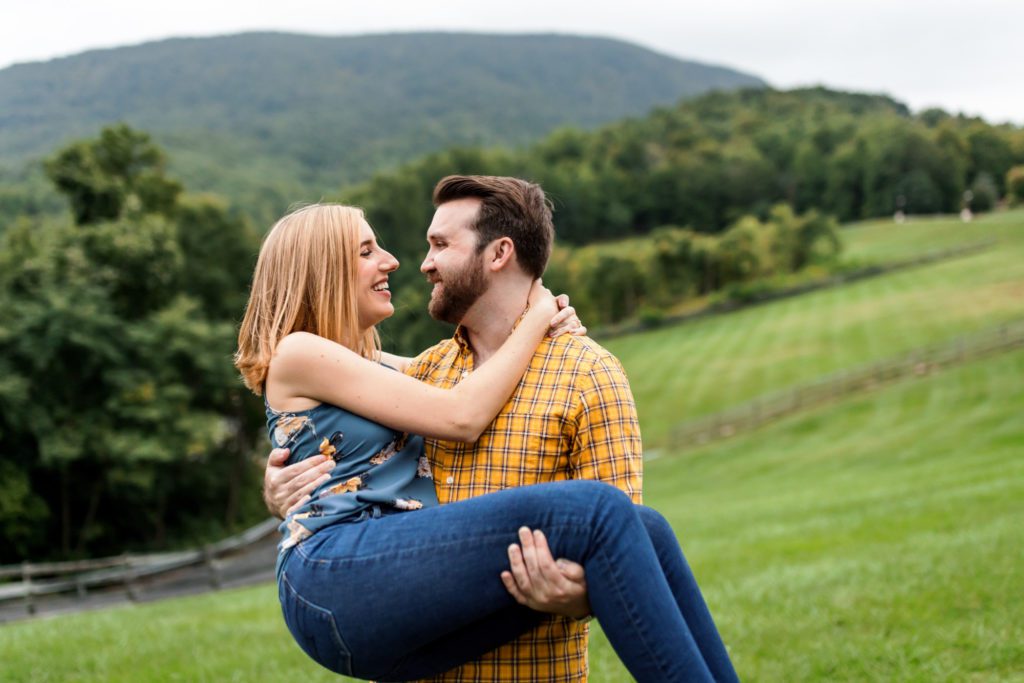 man lifting woman and spinning her around during engagement session