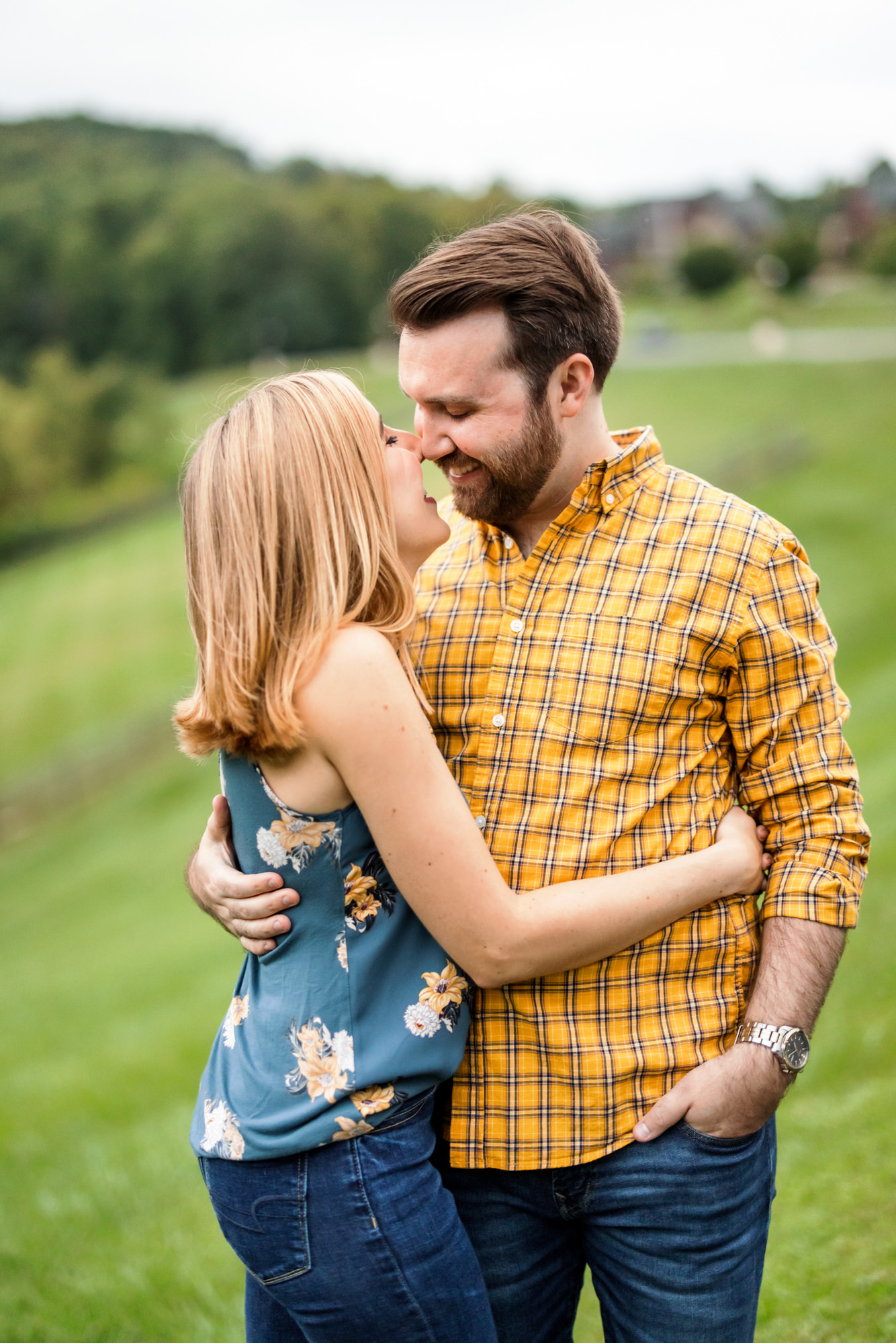 engaged couple wearing navy floral tank, and yellow button down during summer engagement session