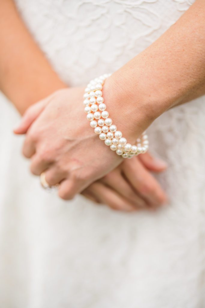 close up of bride's hands and pearl bracelets