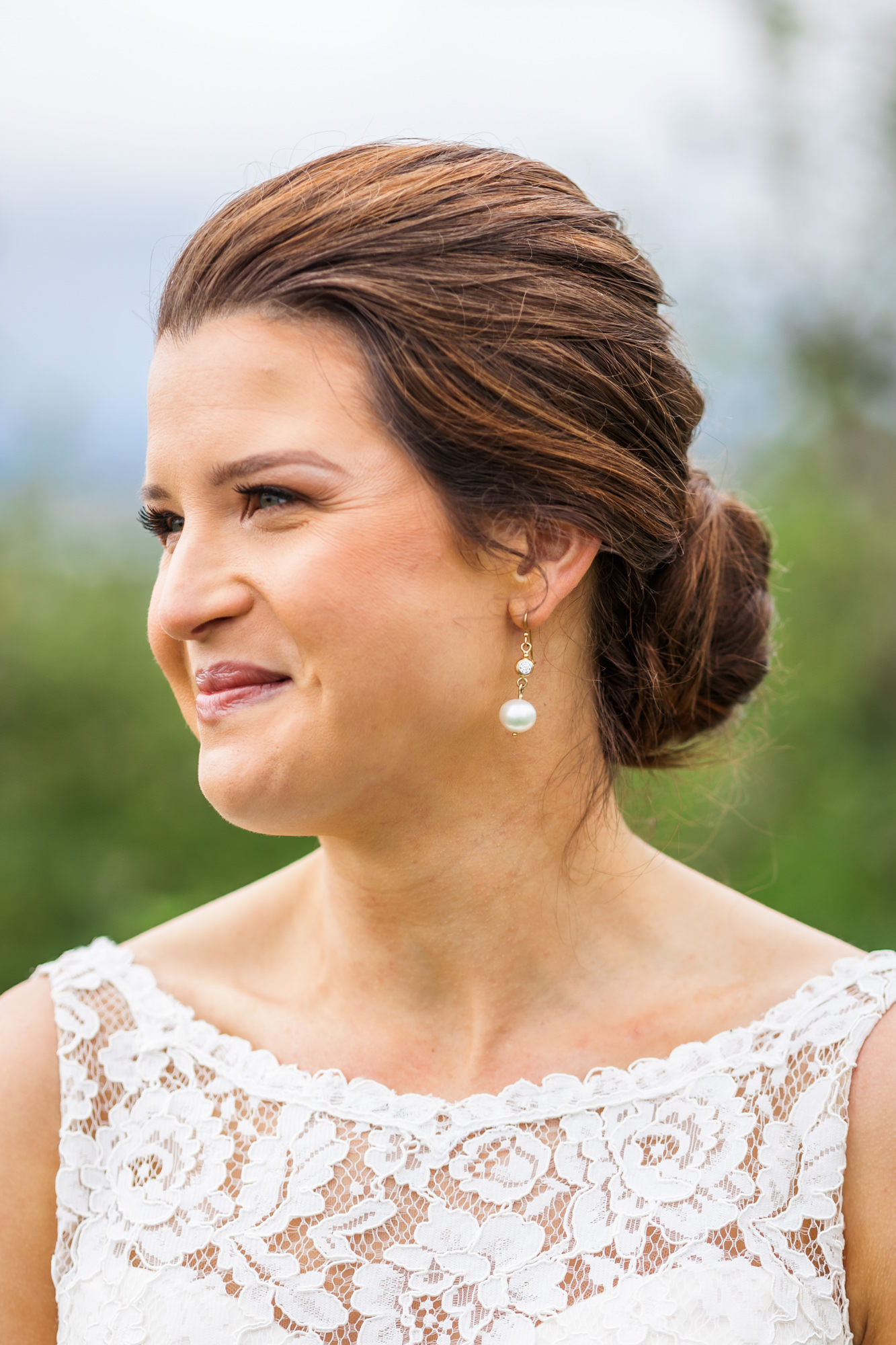 bride smiling with hair in elegant updo bridal hairstyle for showalters greenhouse wedding