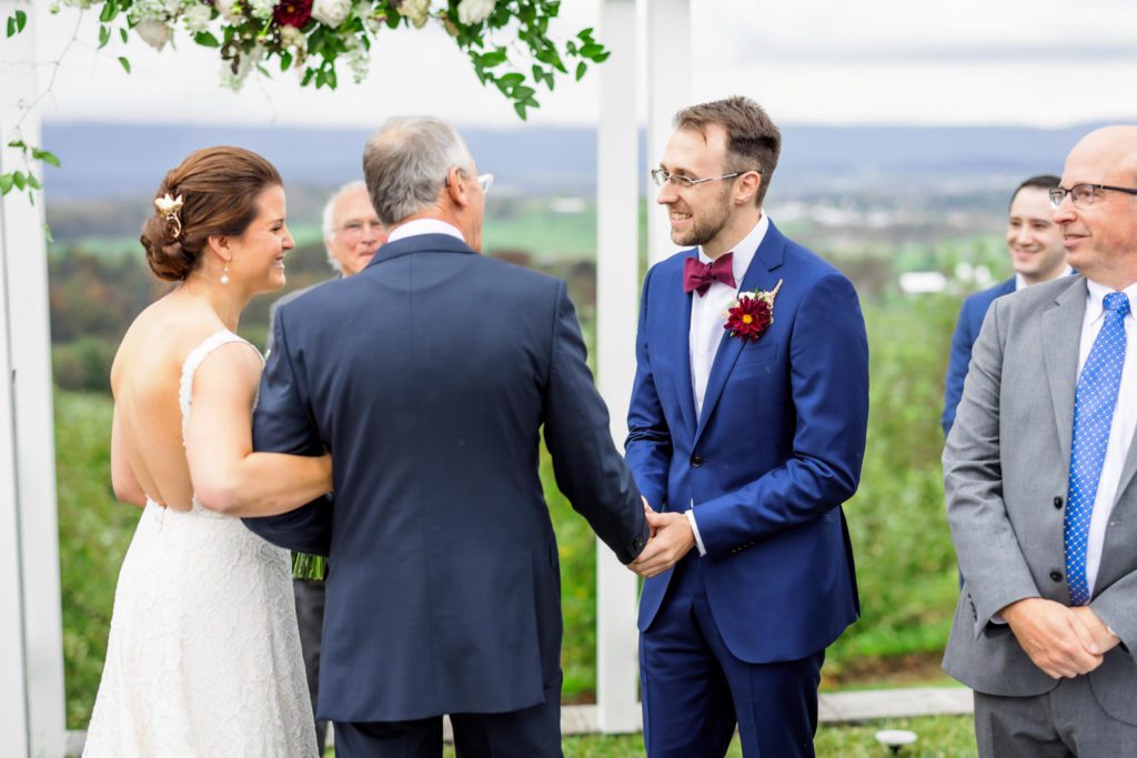 groom shaking bride's father's hand during wedding ceremony