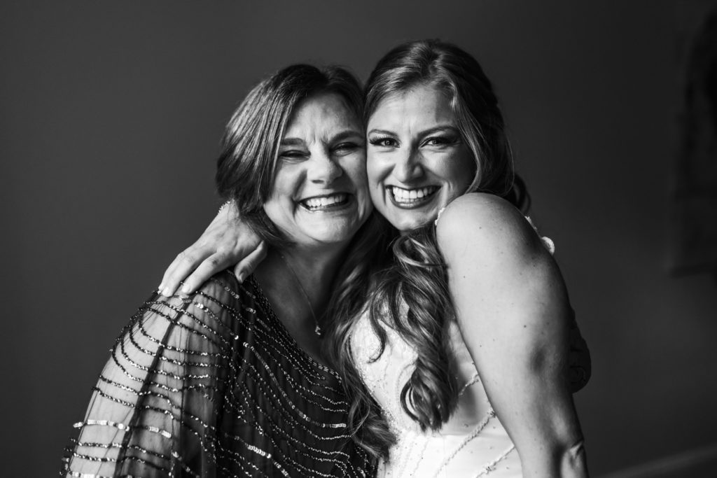 bride hugging family in black and white portrait during getting ready portraits
