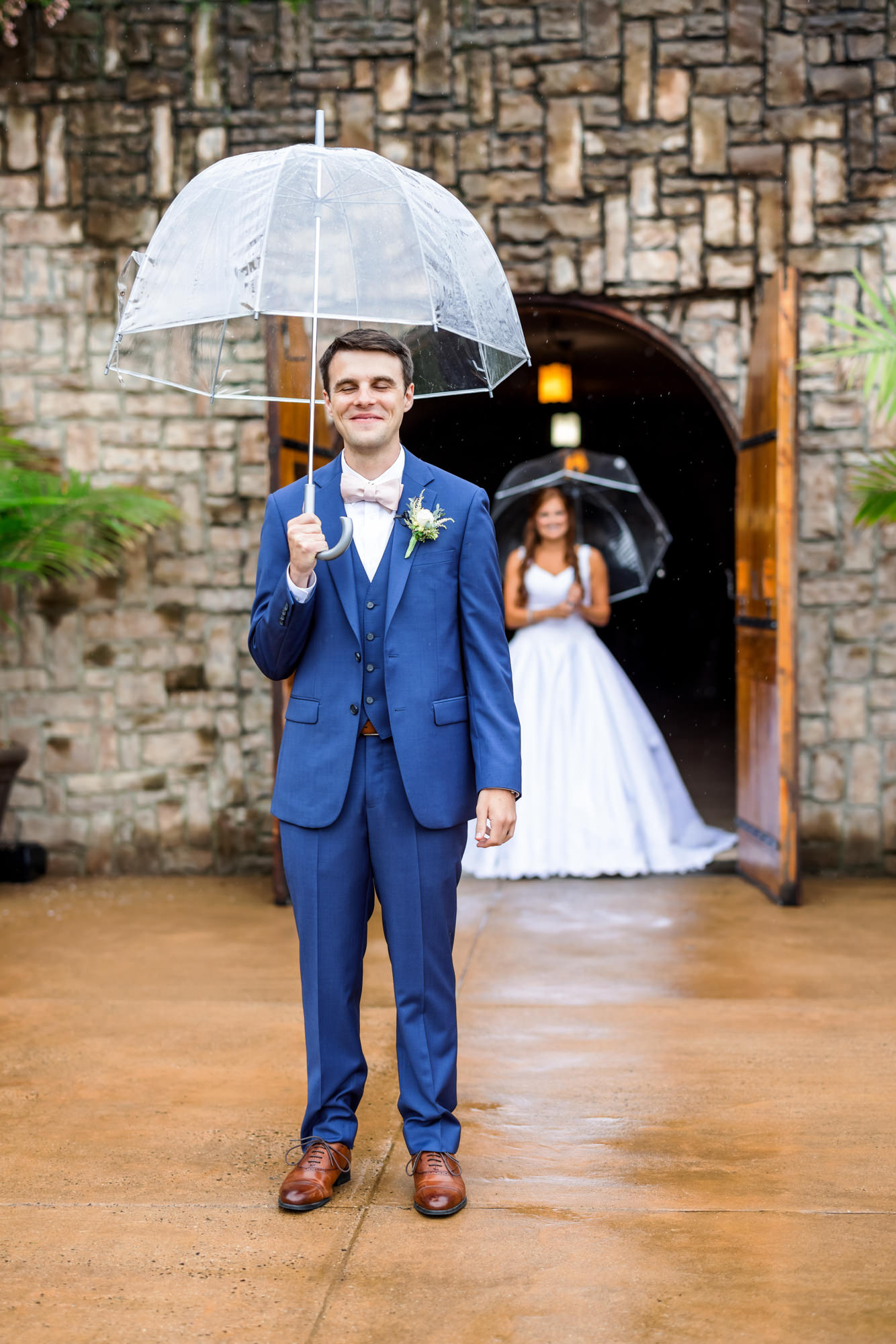 bridal couple during rainy first look holding clear umbrellas