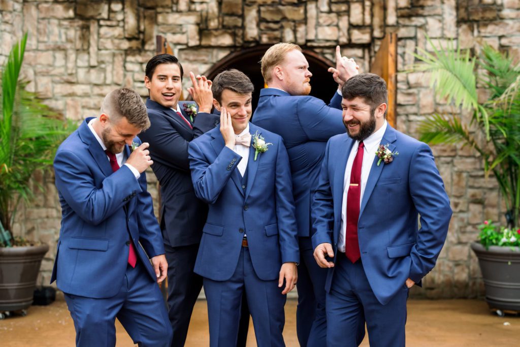 groom laughing with wedding party during groomsmen portraits