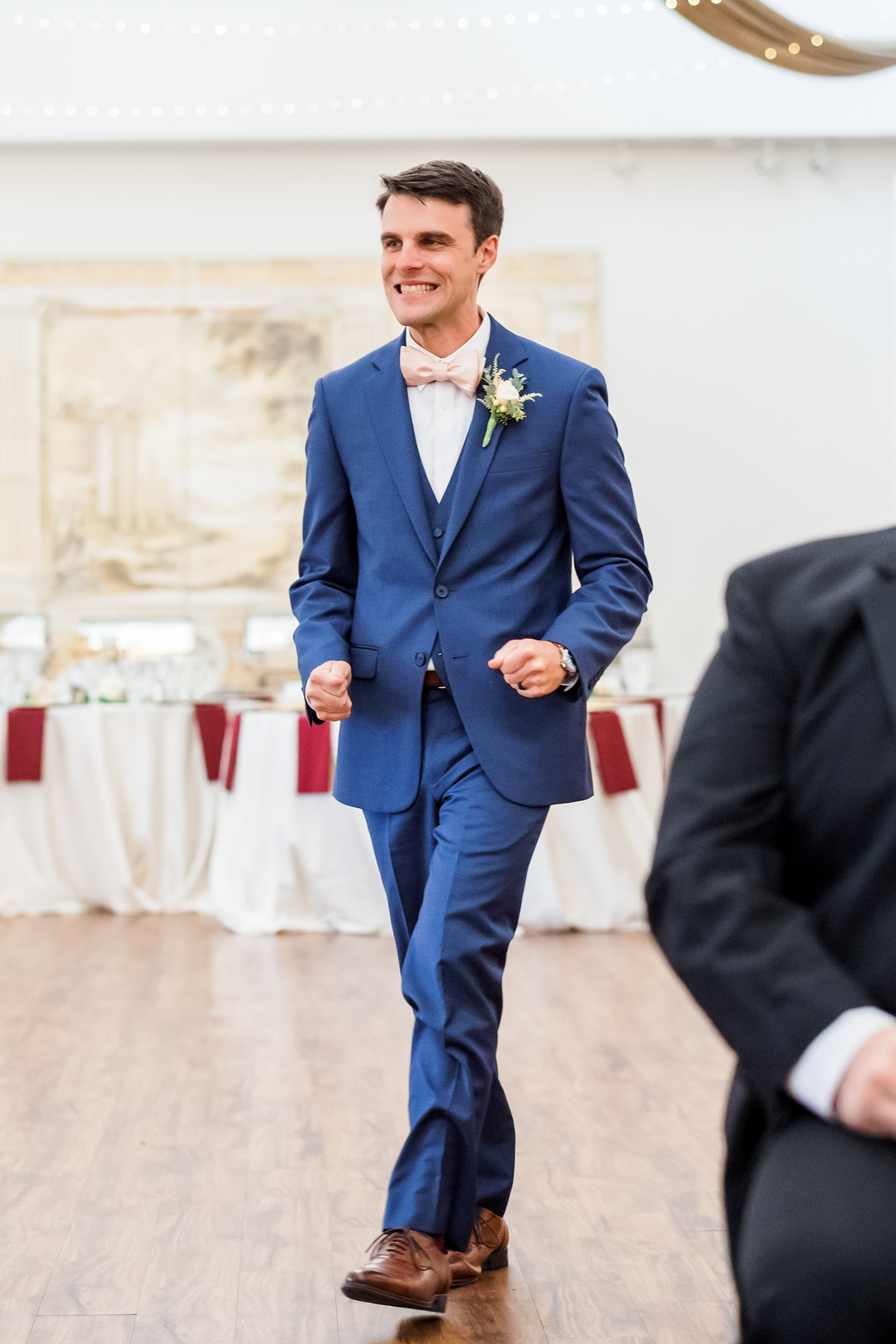 groom walking down aisle with hands in fists