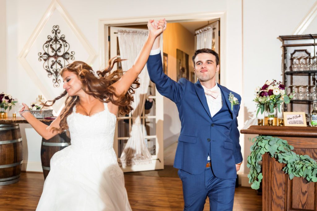 newly married couple dance into wedding reception together