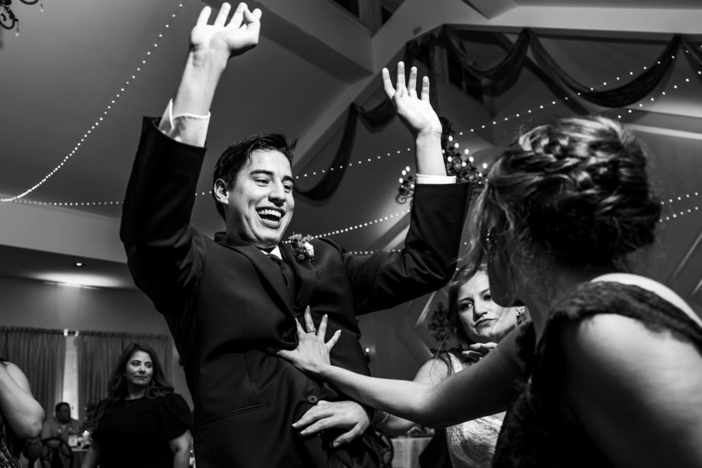 black and white portrait of wedding guests dancing and celebrating