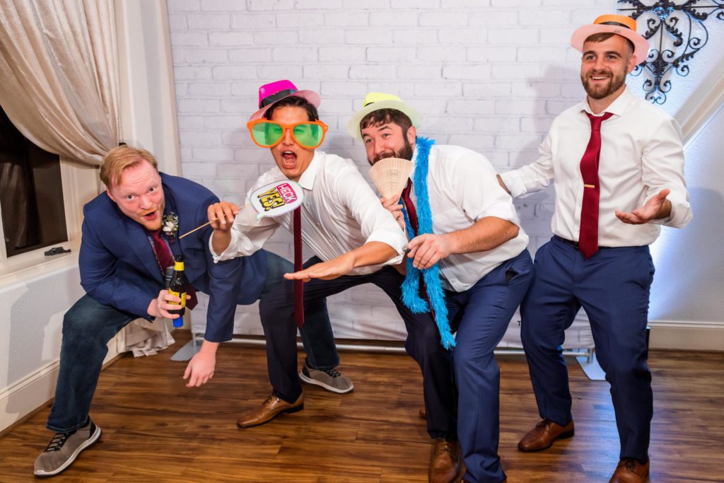 wedding guests wearing photo booth props taking pictures together