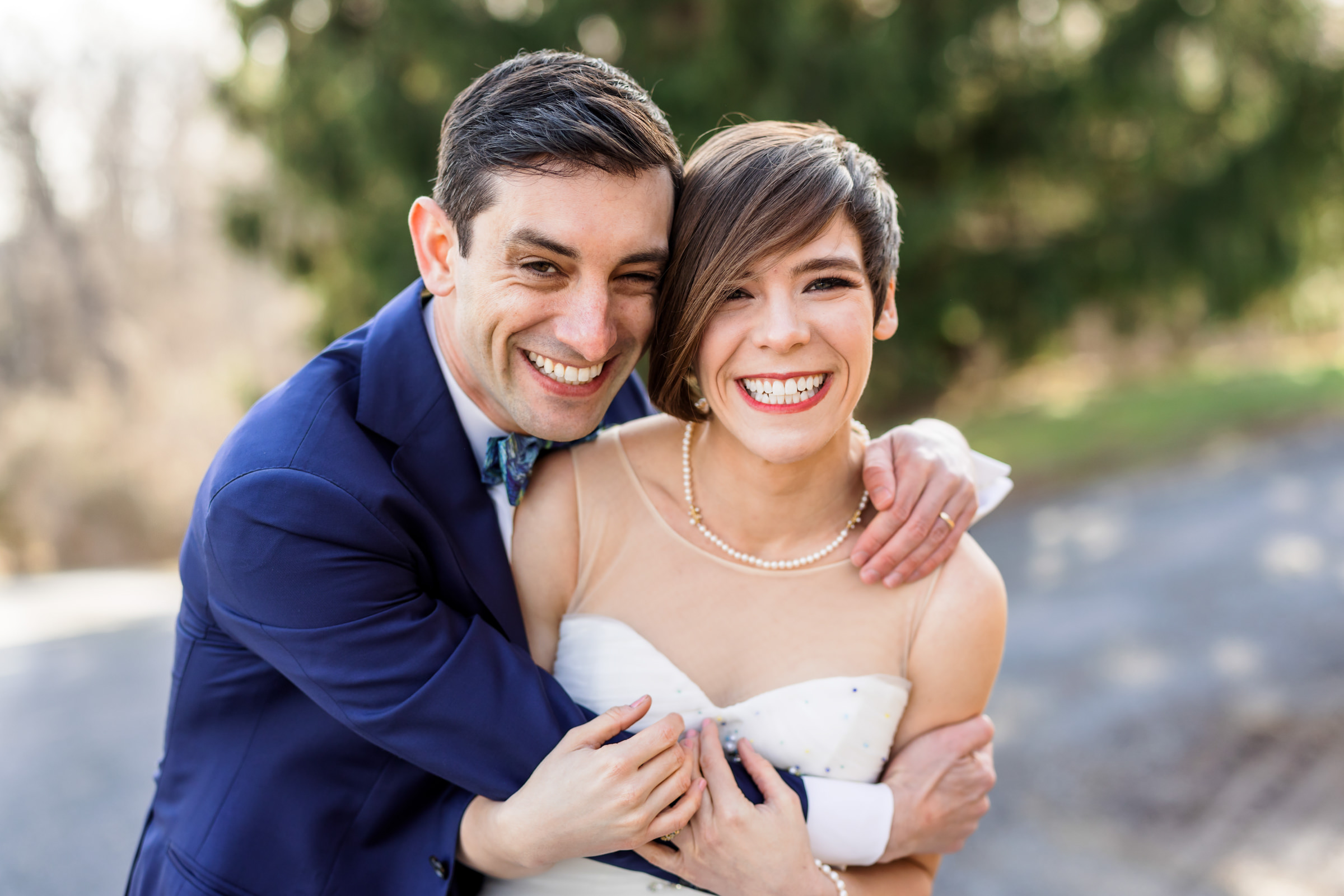 wedding couple embracing and smiling during outdoor portraits