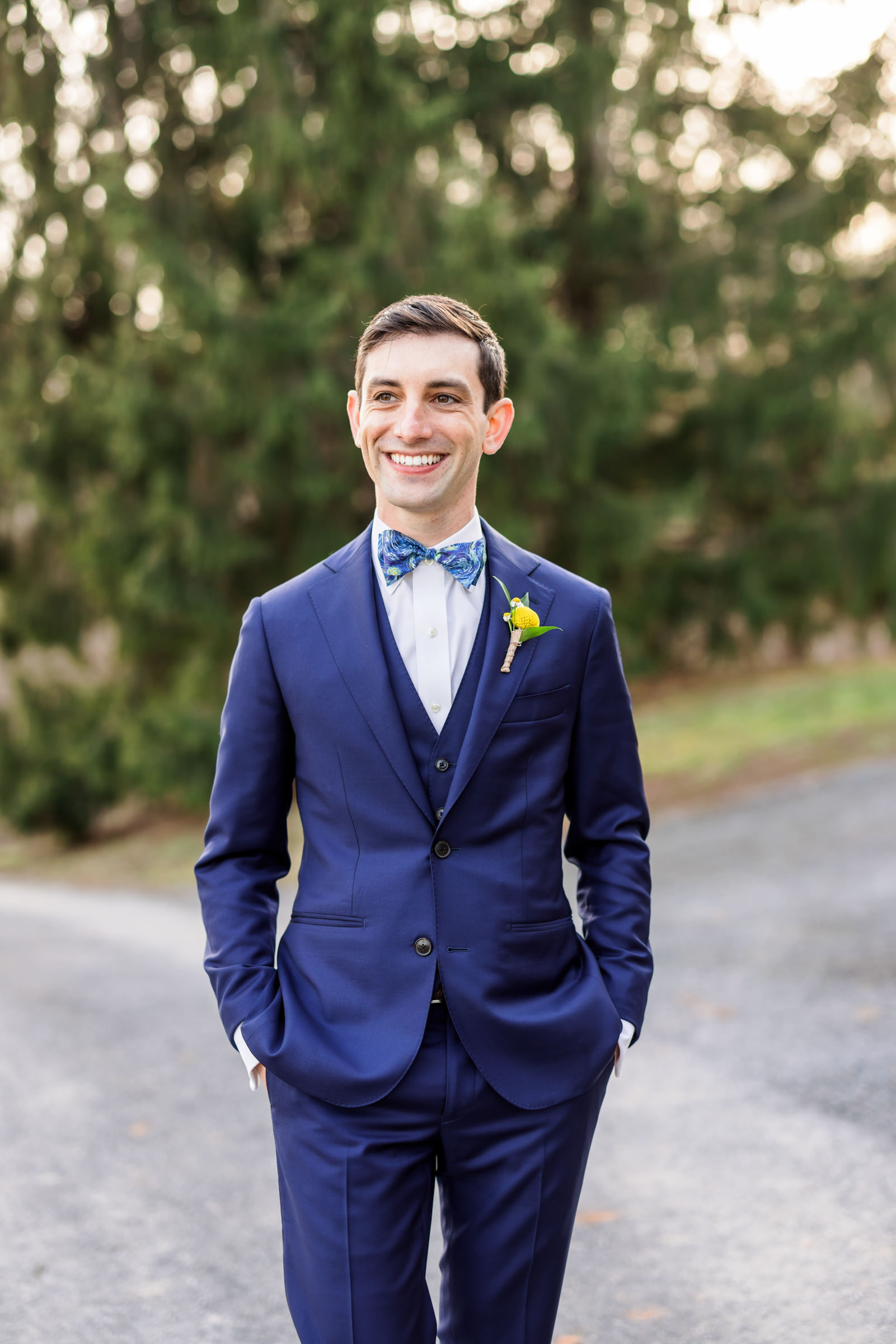 groom wearing navy suit and bow tie with yellow rose boutonnière during Jewish Wedding at Riverside on the Potomac portraits 