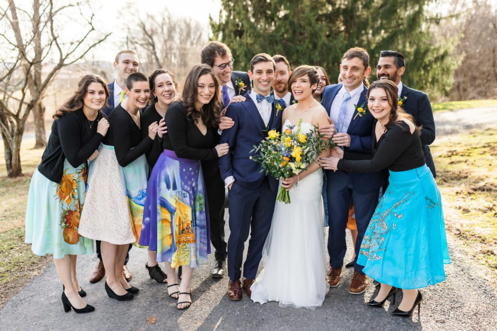 wedding couple being embraced by wedding party wearing van gogh inspired dresses