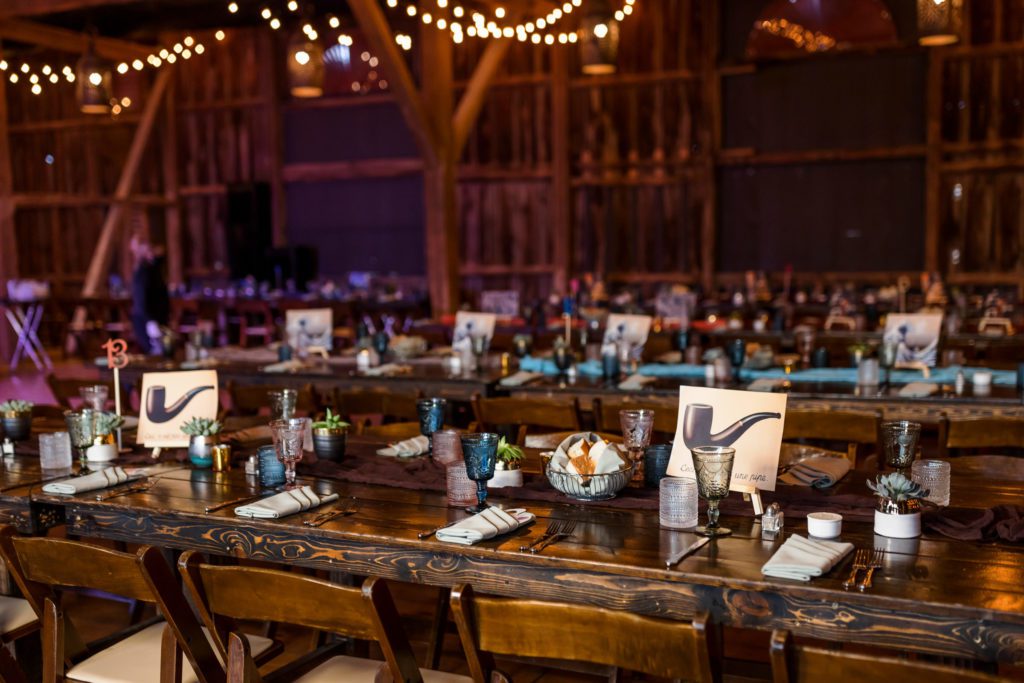 indoor wedding reception featuring wooden tables and string lights at cozy rustic wedding