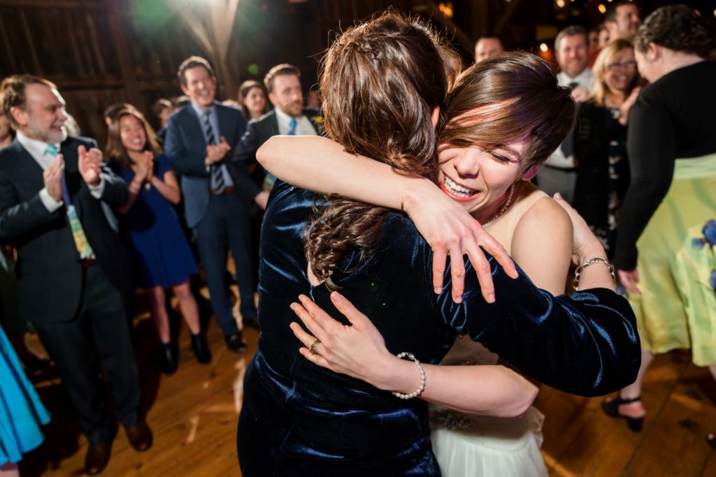 bride hugging wedding guests during evening reception