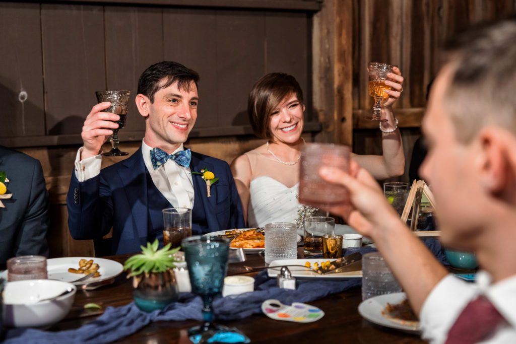 wedding couple lifting glasses and toasting during toasts