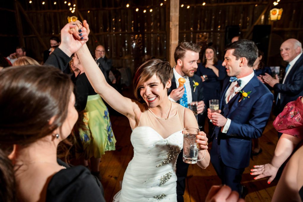 bride holding hands and dancing with guests