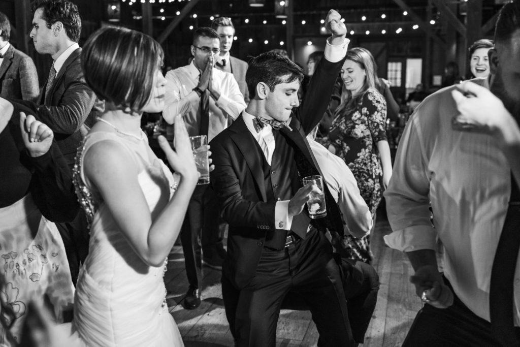 bride and groom dancing together during evening reception in black and white portrait