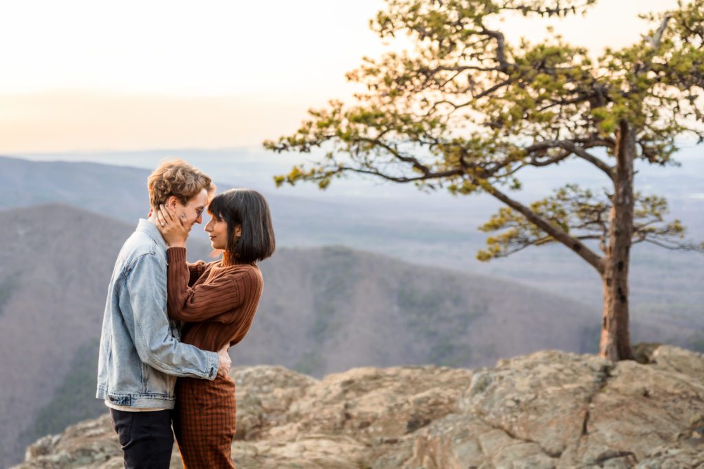 couples portraits at top of Ravens Roost, man wearing jean jacket and woman wearing rust colored sweater