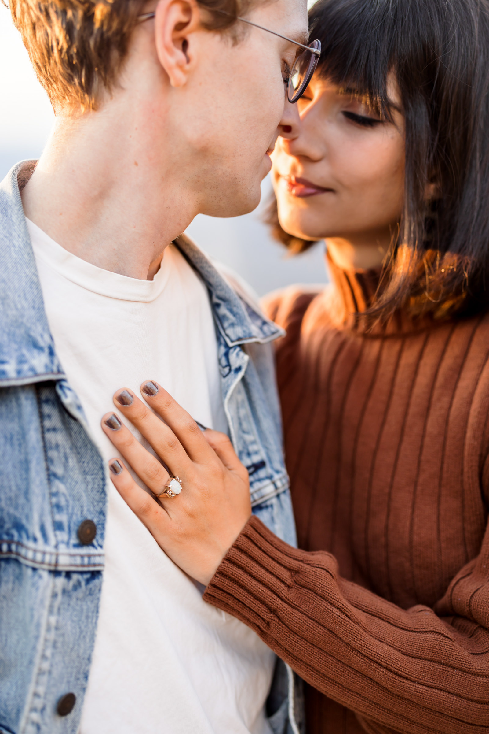 woman's hand on man's chest showcasing engagement ring