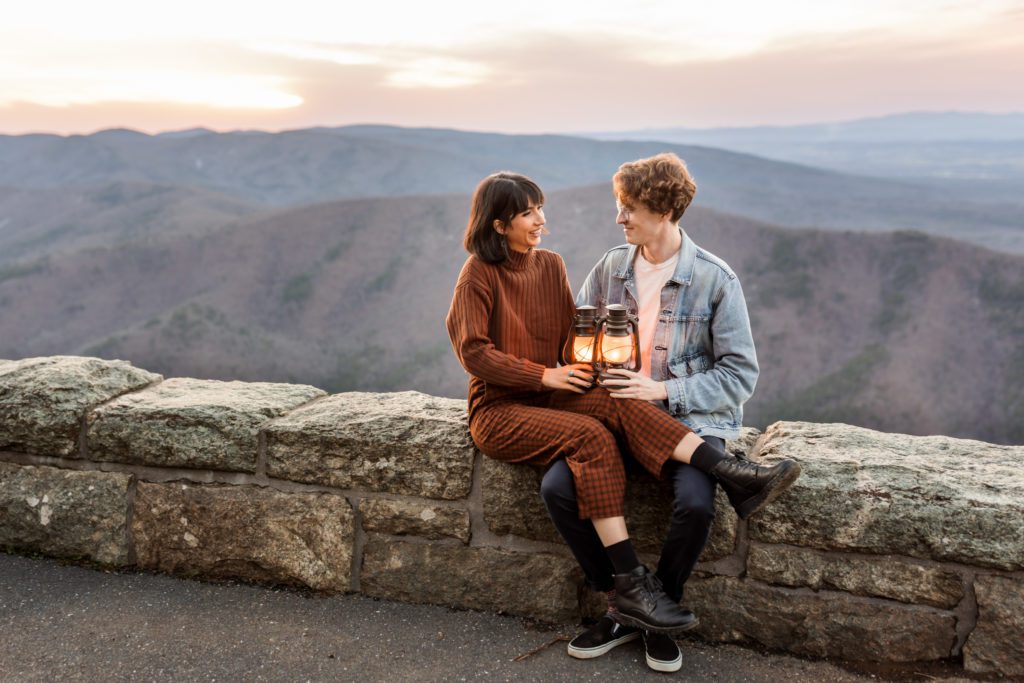 couple sitting on rock wall with lanterns