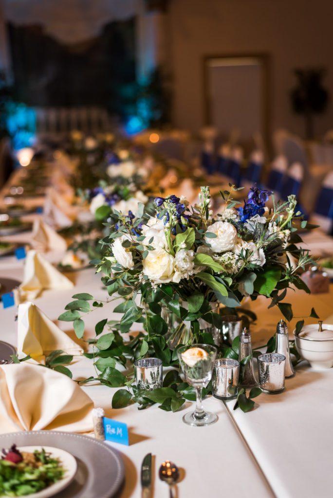 floral centerpiece with greenery and white roses
