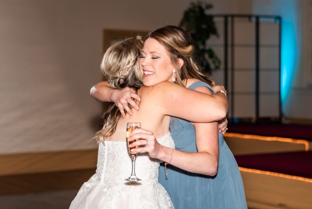 bride hugging bridesmaid after speech at wedding ceremony