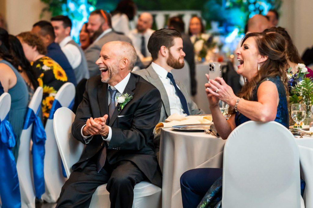 wedding guests laughing during speeches at wedding reception