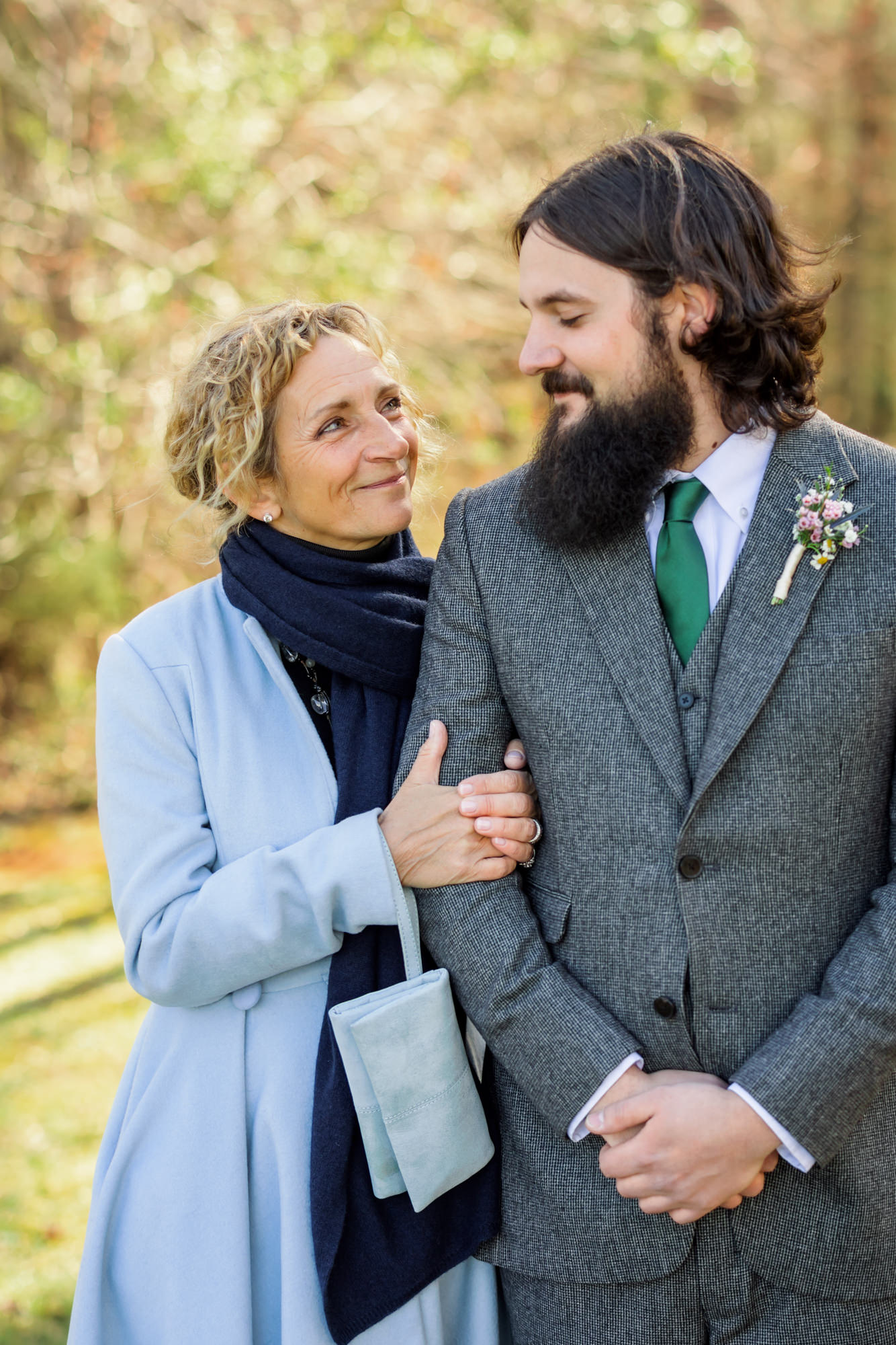 groom with mother before wedding ceremony wearing gray suit and emerald tie