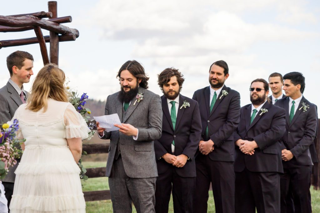 groom reading vows during outdoor spring wedding ceremony