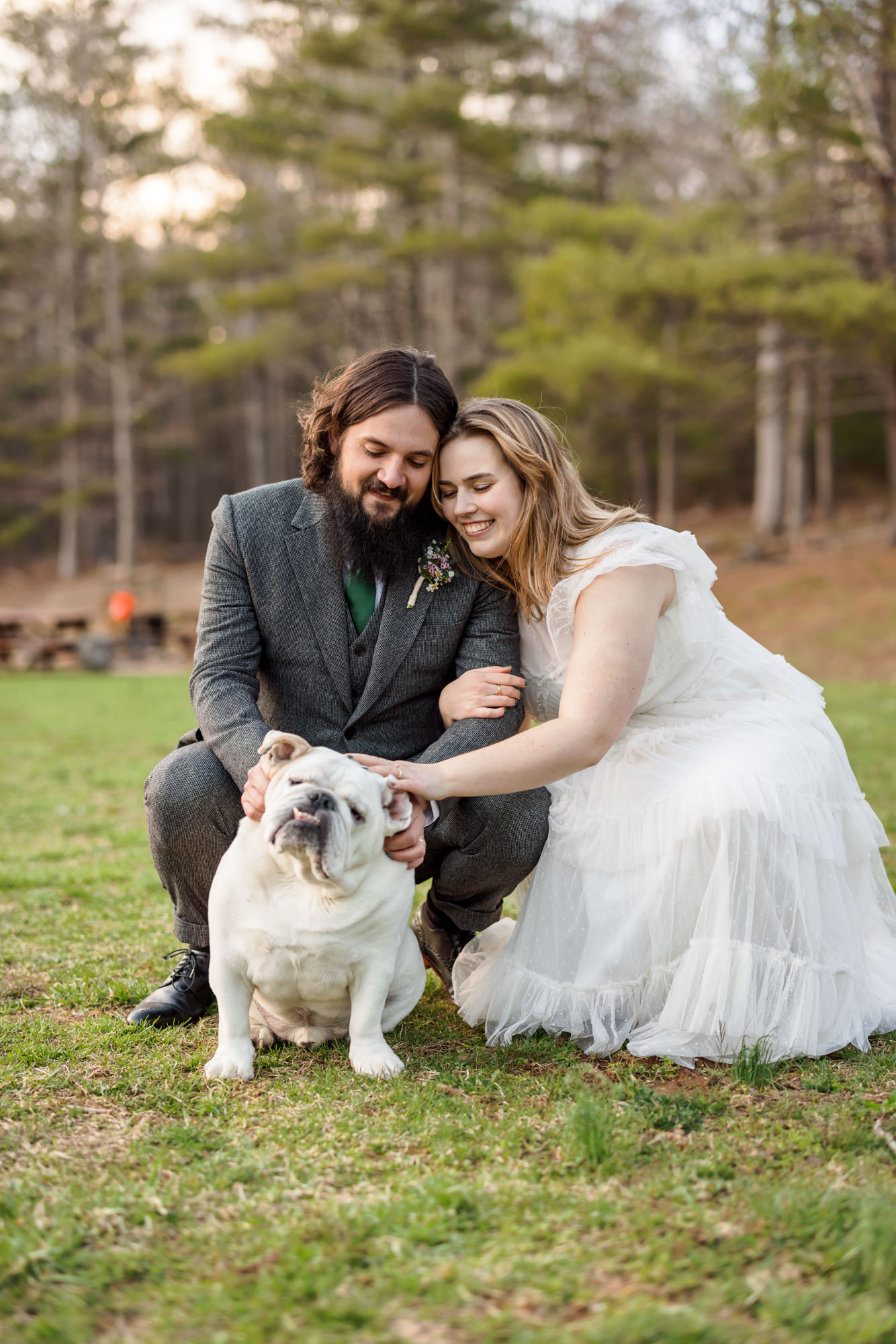 couple sitting together petting dog after ceremony 