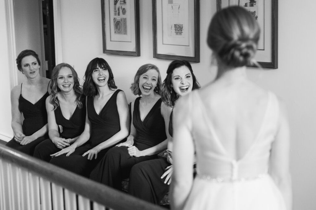 bridesmaids seeing bride for first time in wedding dress on wedding day