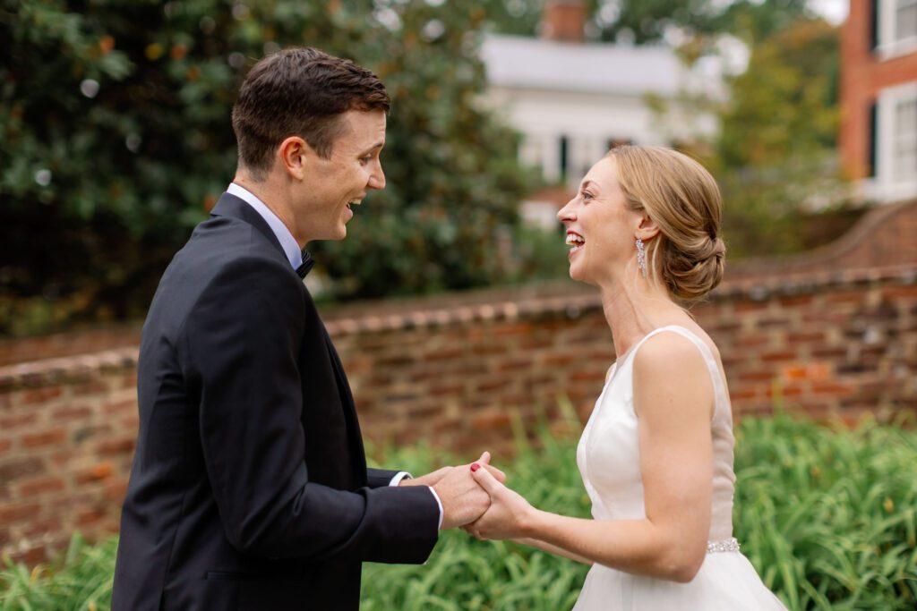 couple laughing together during first look before wedding ceremony