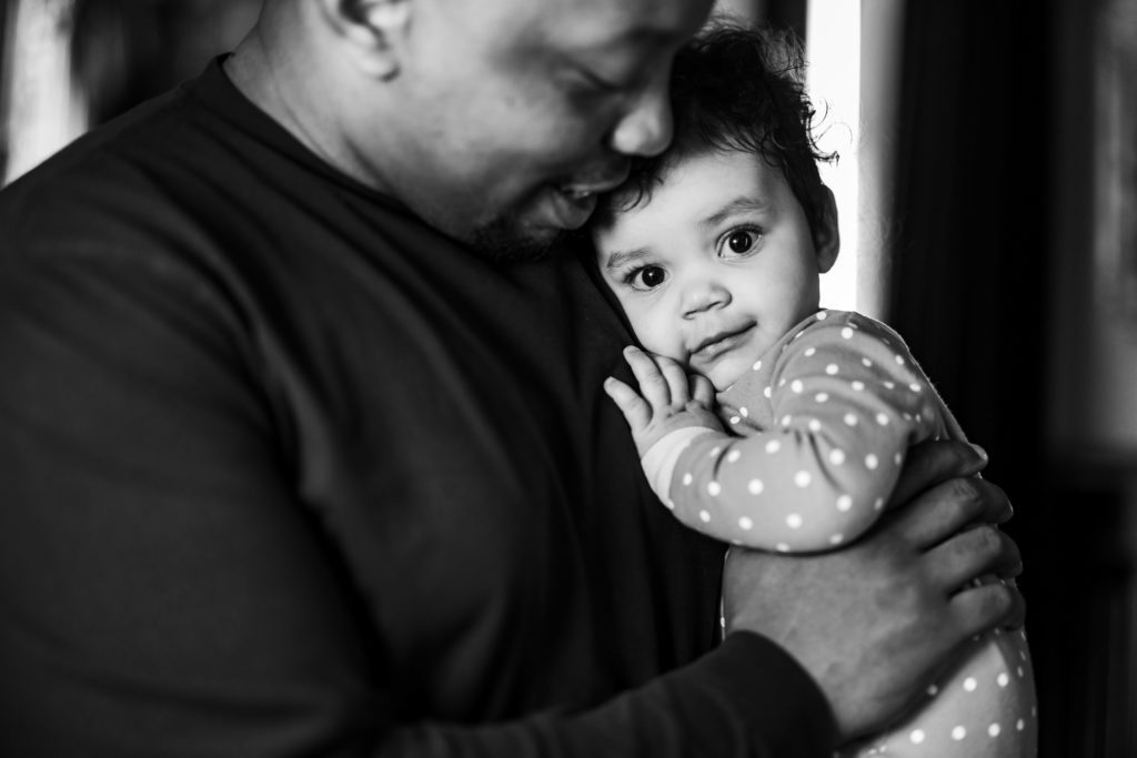 groom holding young daughter while getting ready for spring dover hall wedding day