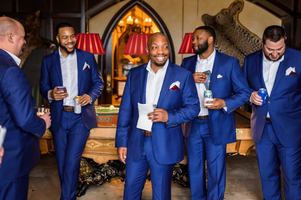 groom wearing blue suits laughing and getting ready before dover hall wedding 