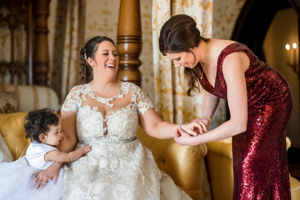 bride laughing while getting ready with bridesmaids and daughter