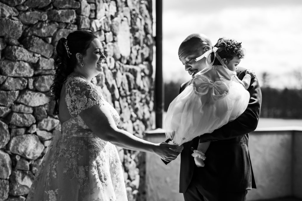 black and white portrait of bride and groom and young daughter