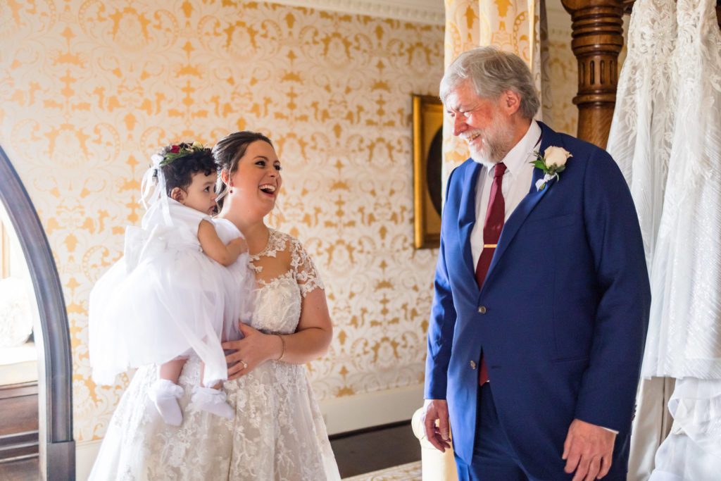 bride laughing and smiling with father during first look