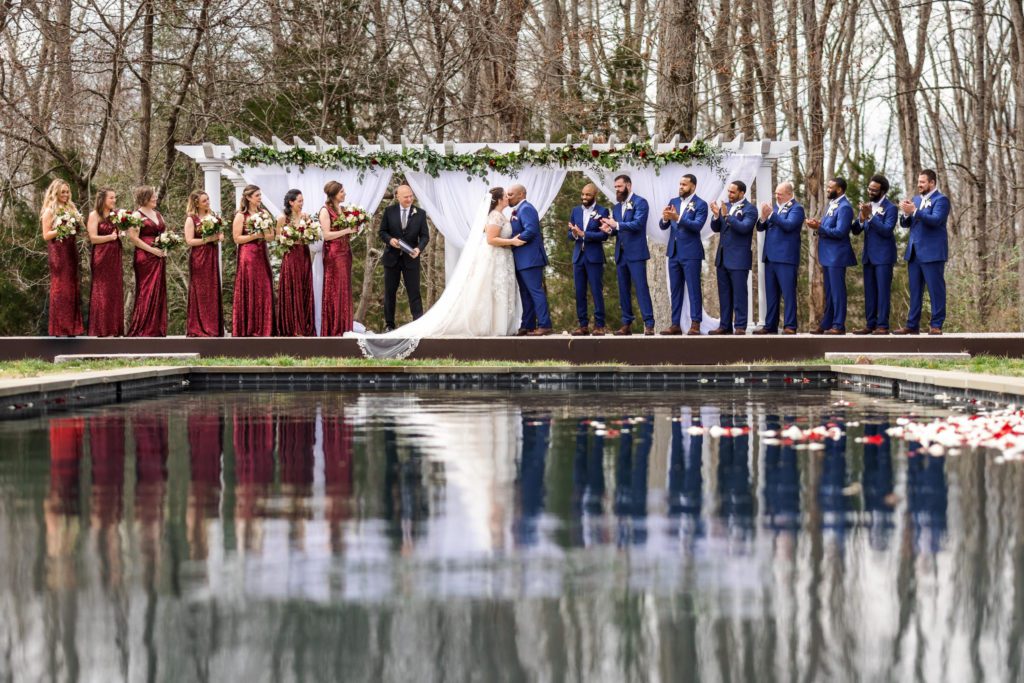 wedding party standing in front of pond together during portraits