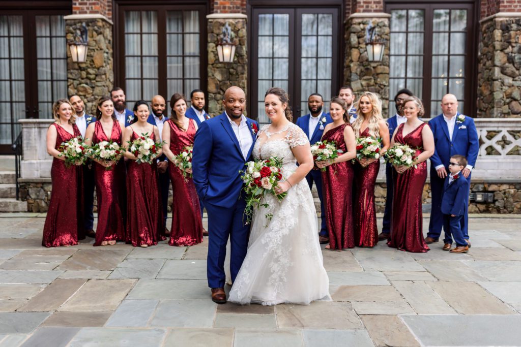 newly married couple standing in front of wedding party during wedding party portraits