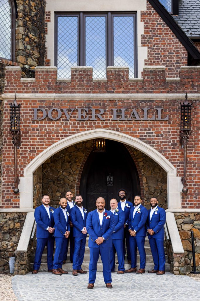 groom wearing blue suit standing with groomsmen wearing blue suits at spring dover hall wedding