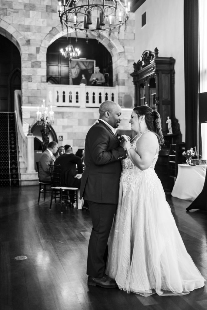 bride and groom dancing during first dance as husband and wife in black and white portrait