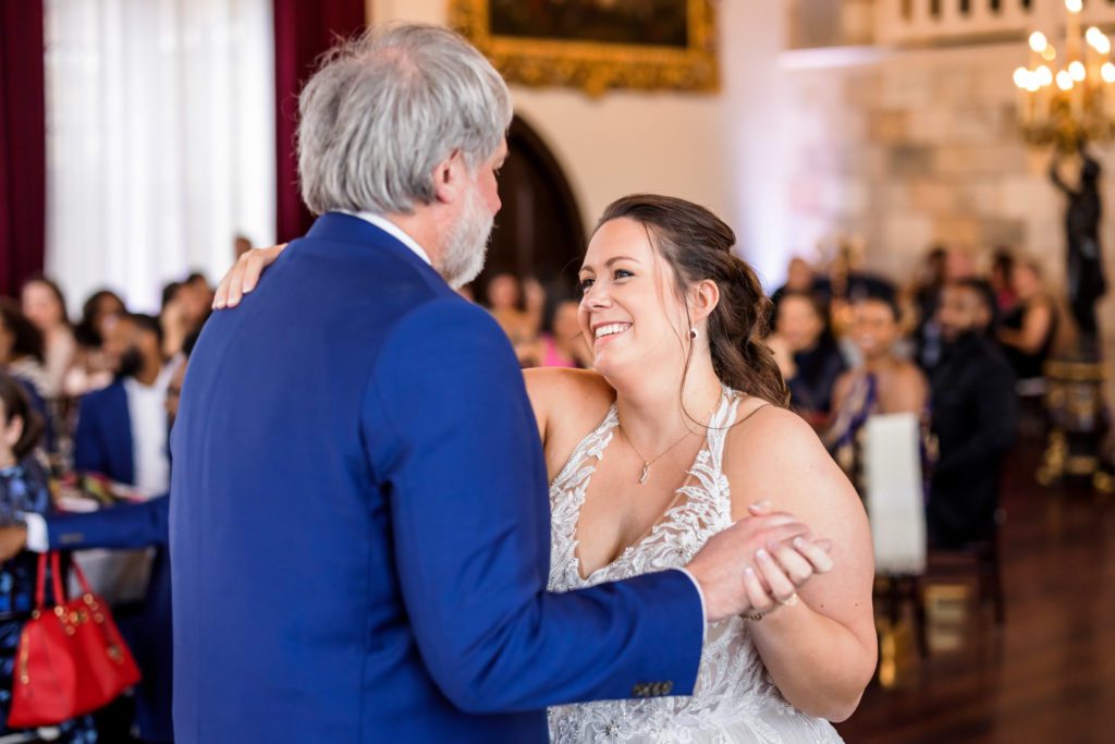 bride wearing halter top wedding dress dancing with father during father-daughter dance