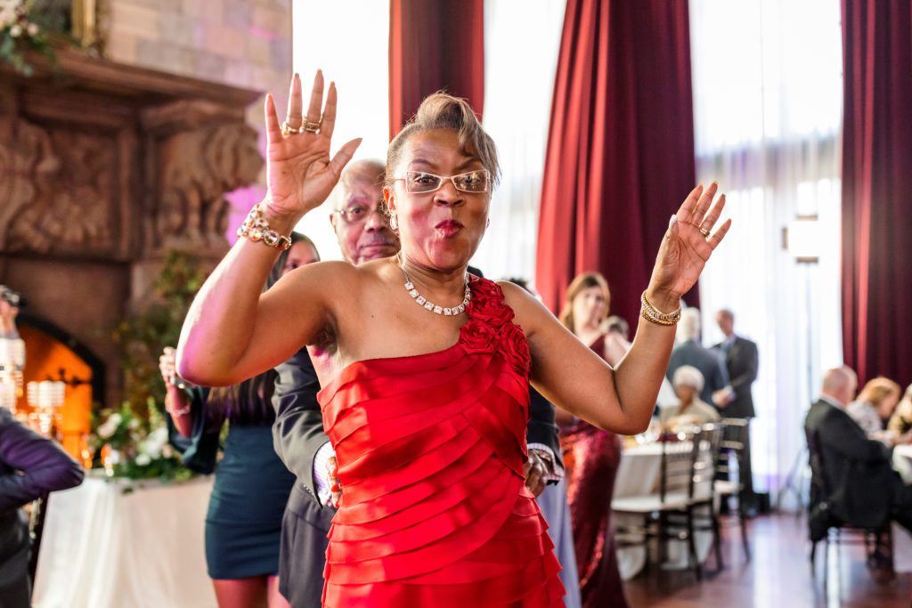 woman wearing red dress with hands up dancing and celebrating 