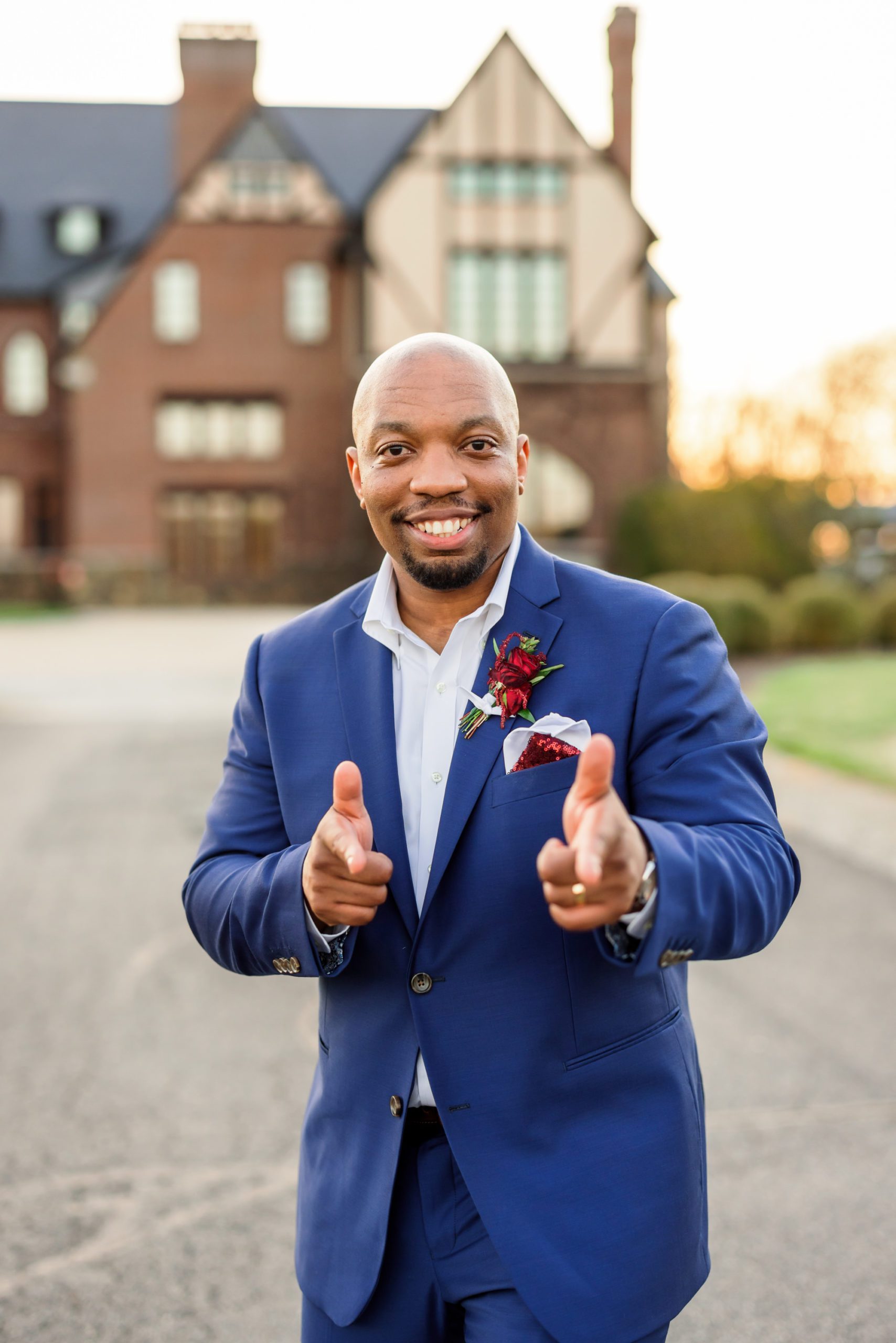 groom pointing finger guns and smiling at camera during portraits