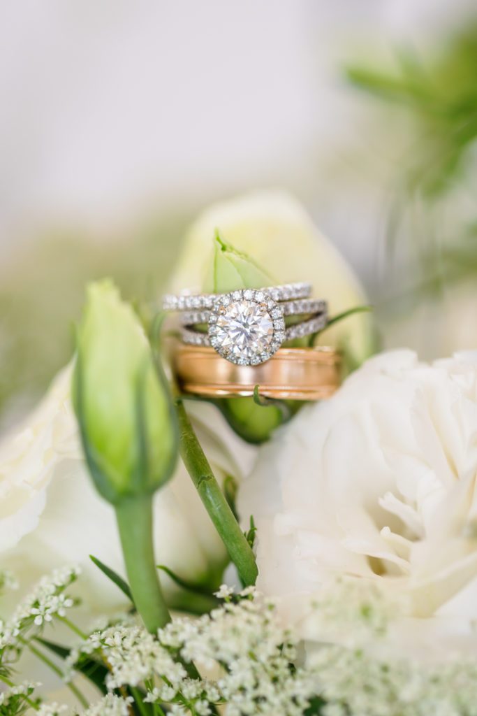 detail ring shot of wedding rings sitting in tulips and roses