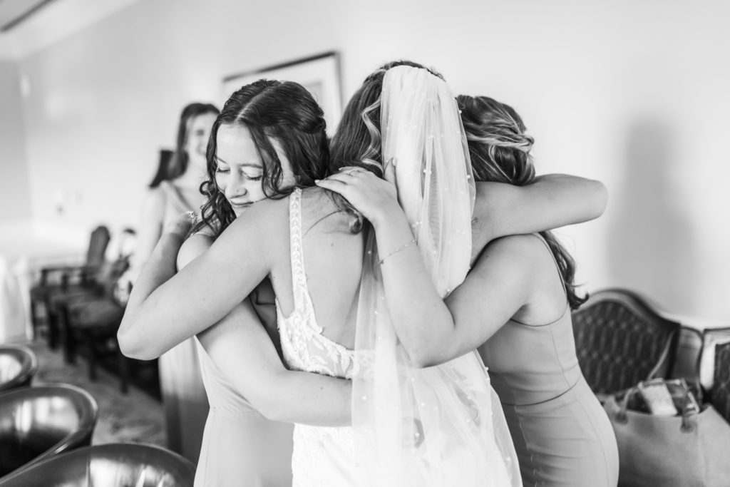 bride hugging bridesmaids before ceremony